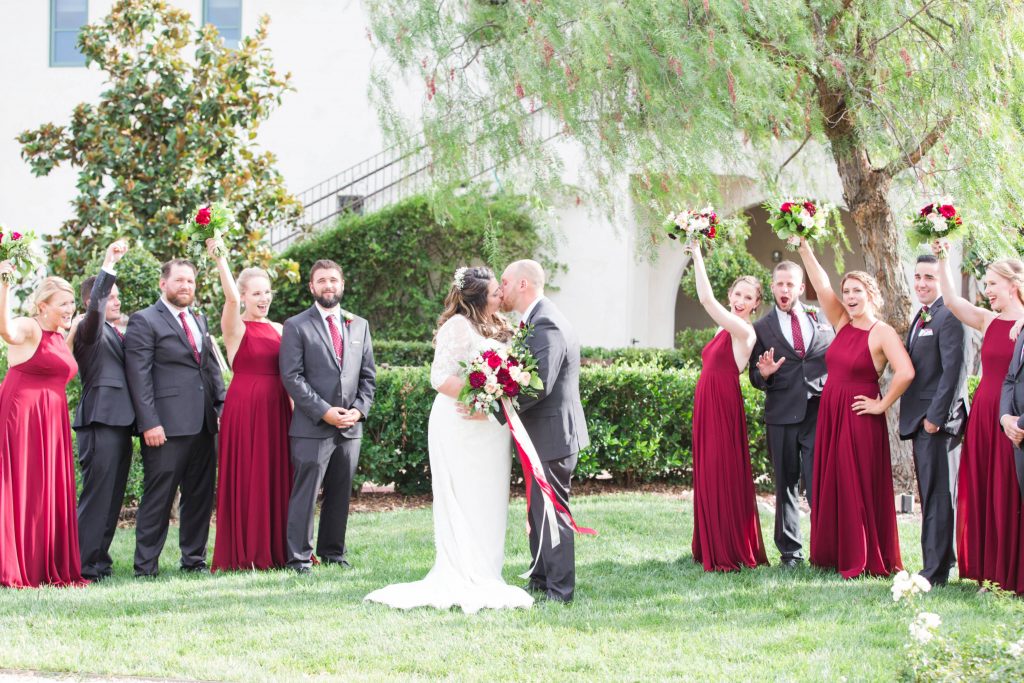 bride and groom kissing with bridal party Carrie McGuire Photography Temecula Wedding Photography Ponte Inn and Winery 