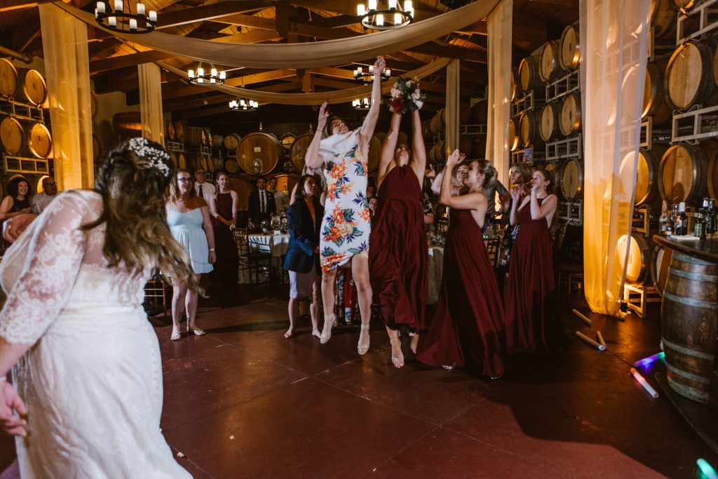 guests jumping for bouquet Carrie McGuire Photography Temecula Wedding Photography Ponte Inn and Winery 