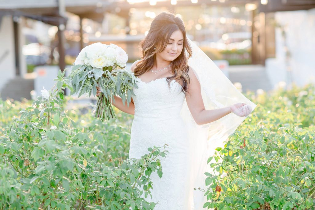 bride in garden with bouquet in beautiful summer light Lakehouse San Marcos Carrie McGuire Photography Temecula Wedding Photography
