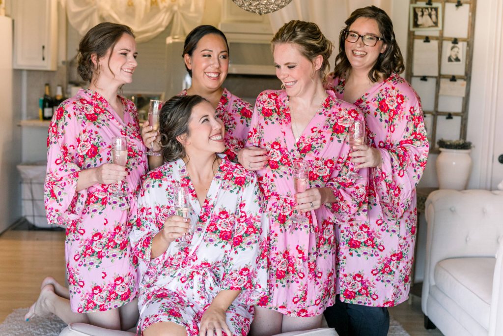 bride and bridesmaids cheers champagne in pretty robes