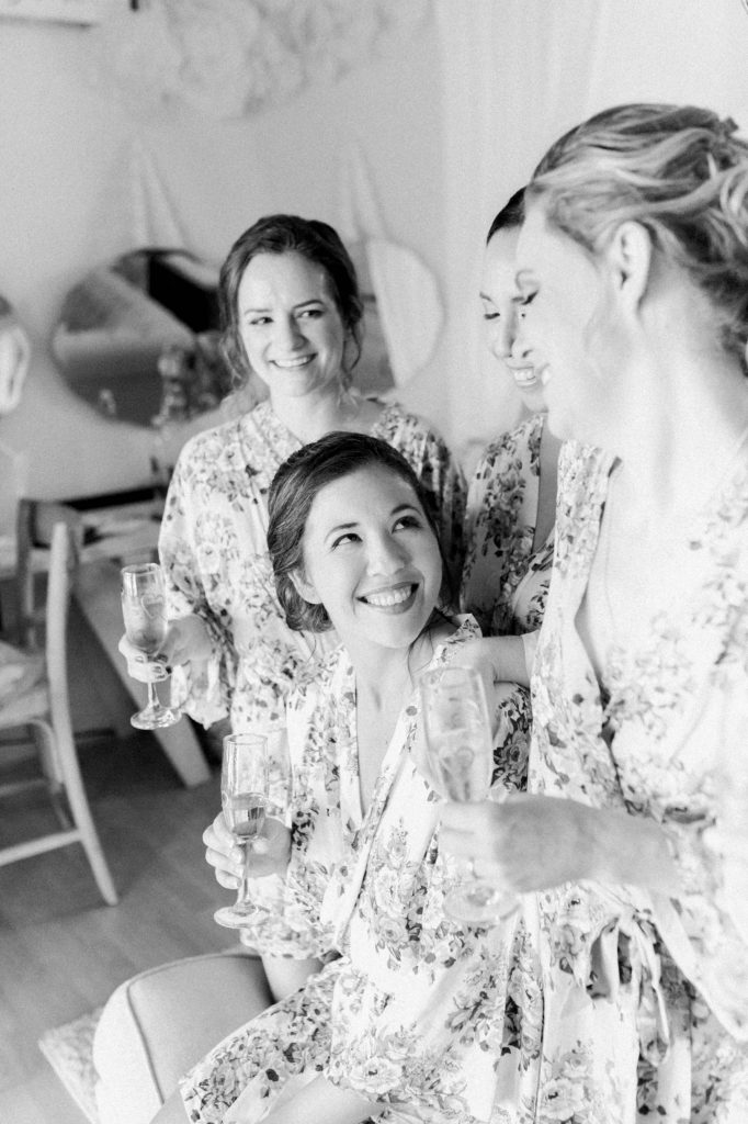 bride with her bridesmaids in the getting room at forever and always farm