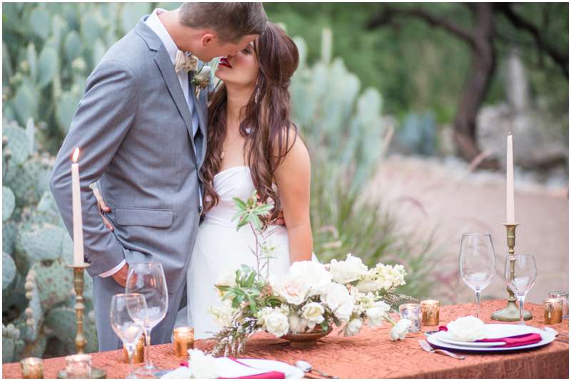 Carrie McGuire photography Temecula photographer Bride and groom kissing by the bridal table Tucson Arizona Wedding photographers