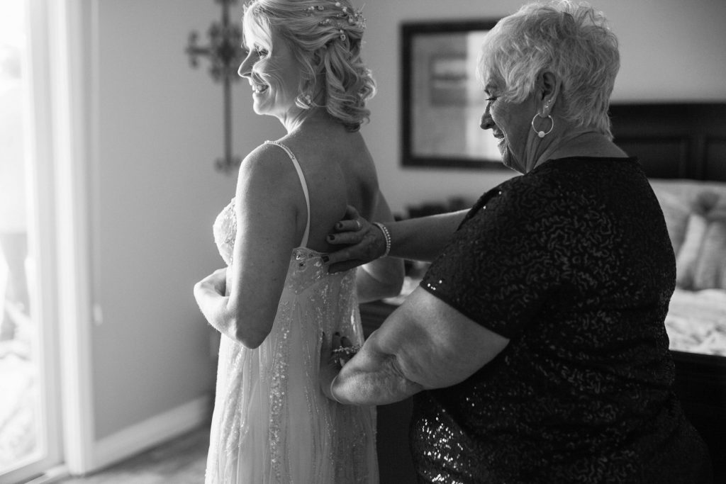 mother of the bride helping bride get dressed Meadowview backyard wedding Carrie McGuire Temecula wedding Photography 