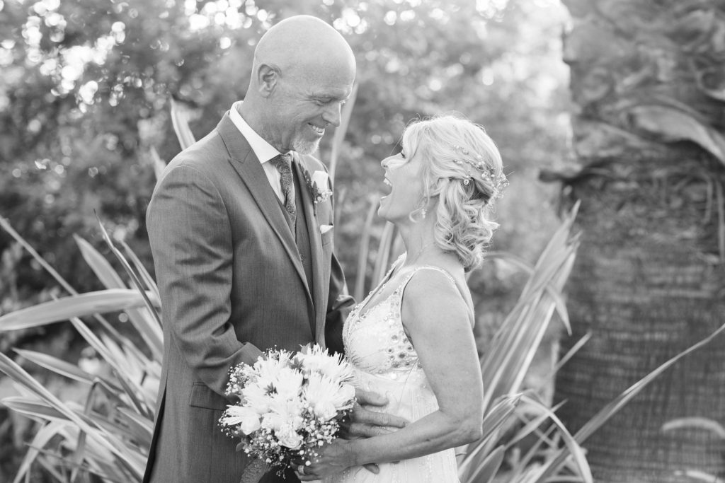 black and white happy bride and groom laughing together Meadowview backyard wedding Carrie McGuire Temecula wedding Photography 