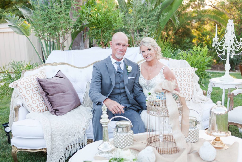 Bride and groom sitting on beautiful couch Meadowview backyard wedding Carrie McGuire Temecula wedding Photography 