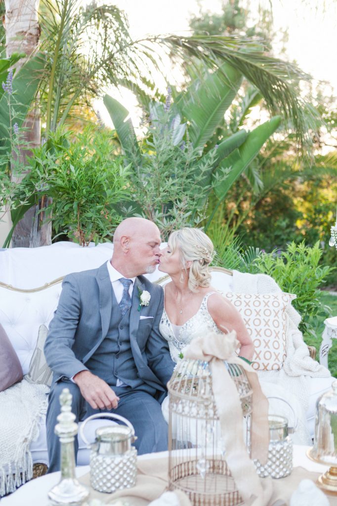bride and groom kissing on couch Meadowview backyard wedding Carrie McGuire Temecula wedding Photography 