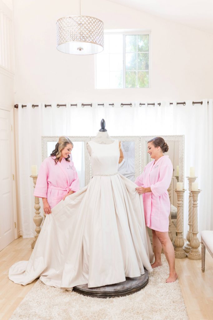 bride and maid of honor admire bridal gown forever and always farm temecula wedding engagement photography Carrie McGuire photographer california
