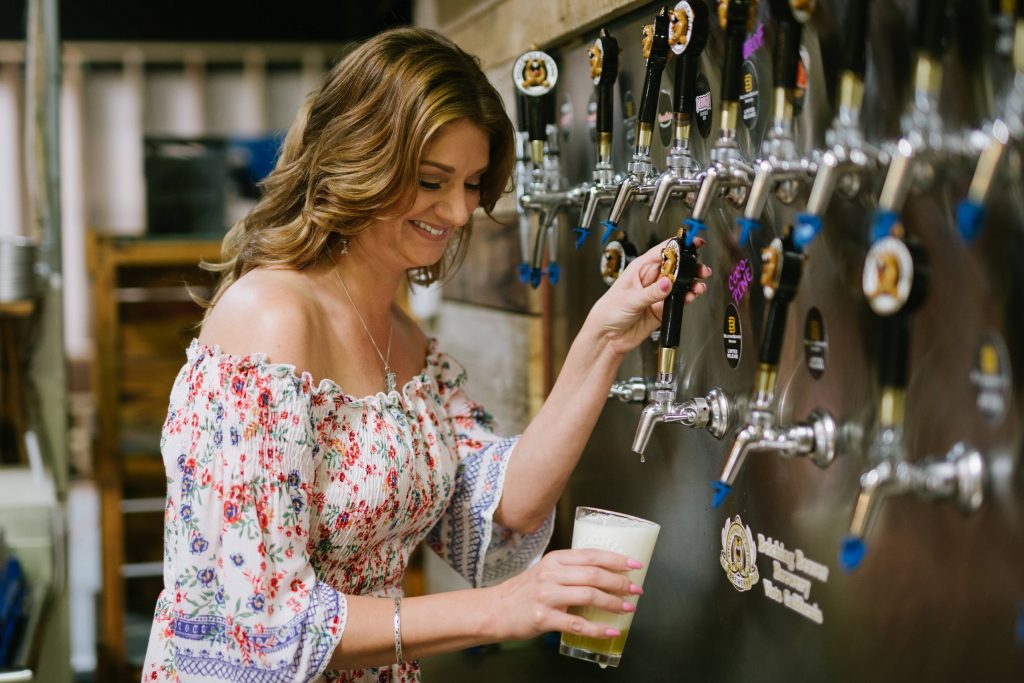 happy newly engaged bride pouring beer belching beaver vista California Carrie McGuire Temecula wedding engagement Photography 
