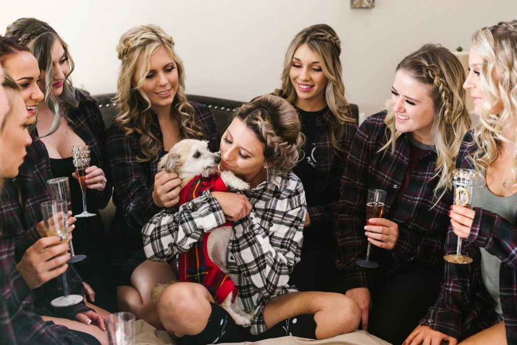 bride and bridesmaids before wedding having champagne and playing with a dog Temecula Coachhouse California wedding engagement photography Carrie McGuire photographer California
