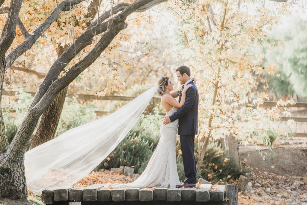 bride and groom posing together on a dock with veil Temecula Coachhouse California wedding engagement photography Carrie McGuire photographer California