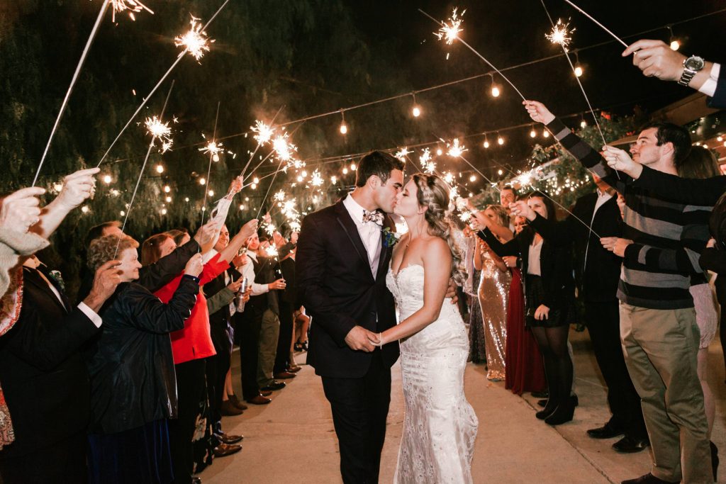 happy newlyweds kissing with guests holding sparklers to light the way Temecula Coachhouse California wedding engagement photography Carrie McGuire photographer California