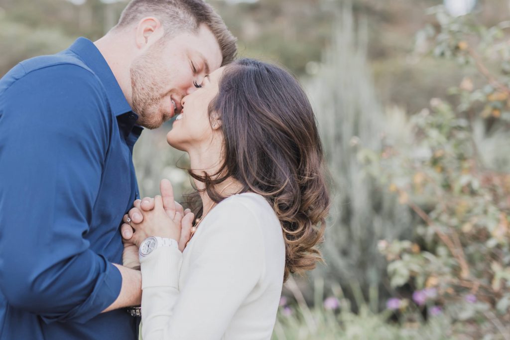 engaged couple kissing in a garden Temecula wedding and engagement photographer session rose heritage gardens California wedding engagement photography Carrie McGuire California