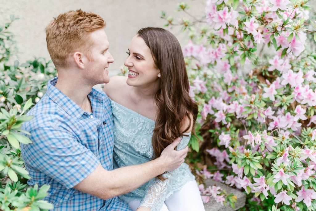 engaged couple in beautiful spring flowers at clairmont pomona college engagement session Temecula wedding photography engagement photos Carrie McGuire Photographer