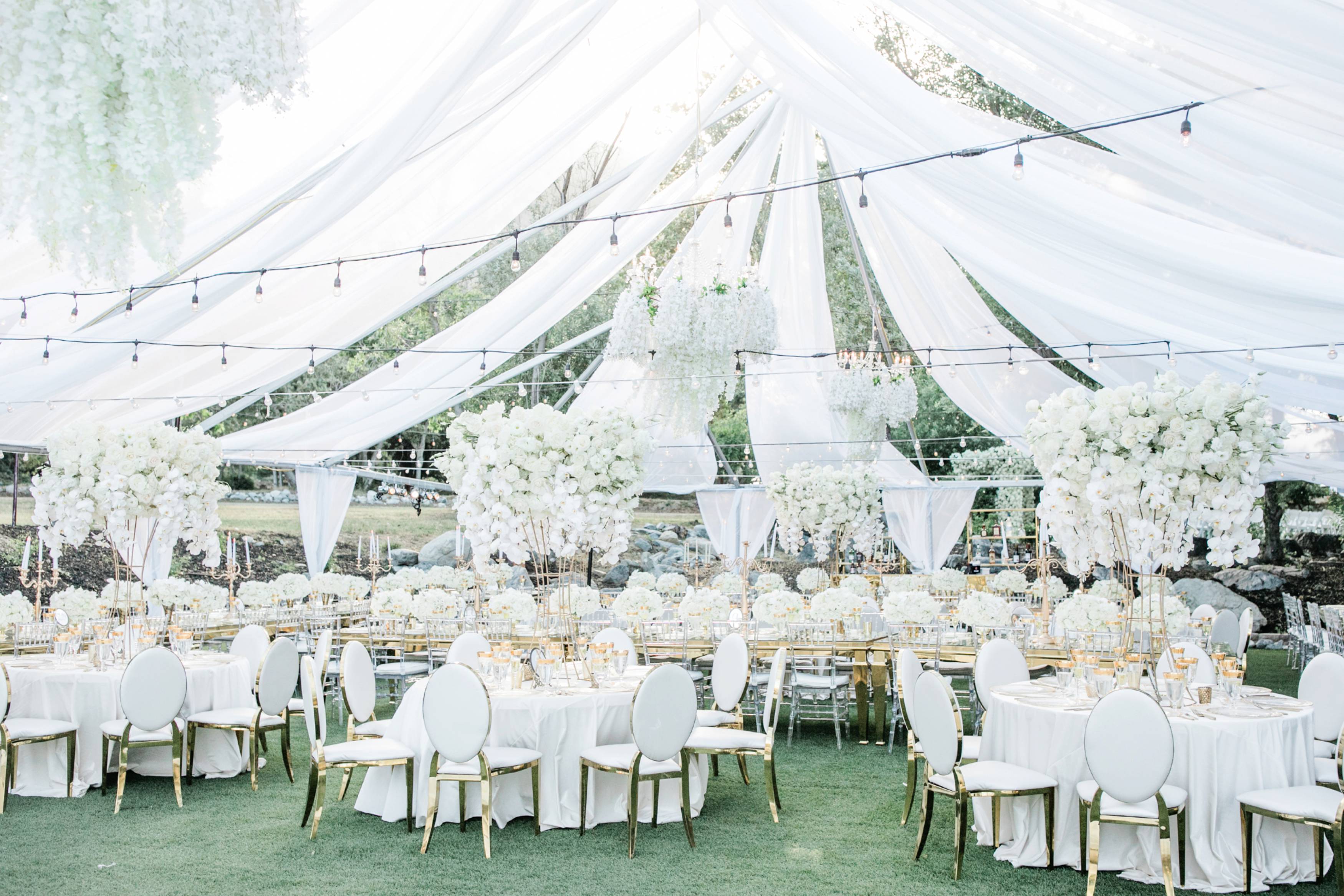 Beautiful clear top wedding reception with white and gold wedding decor
