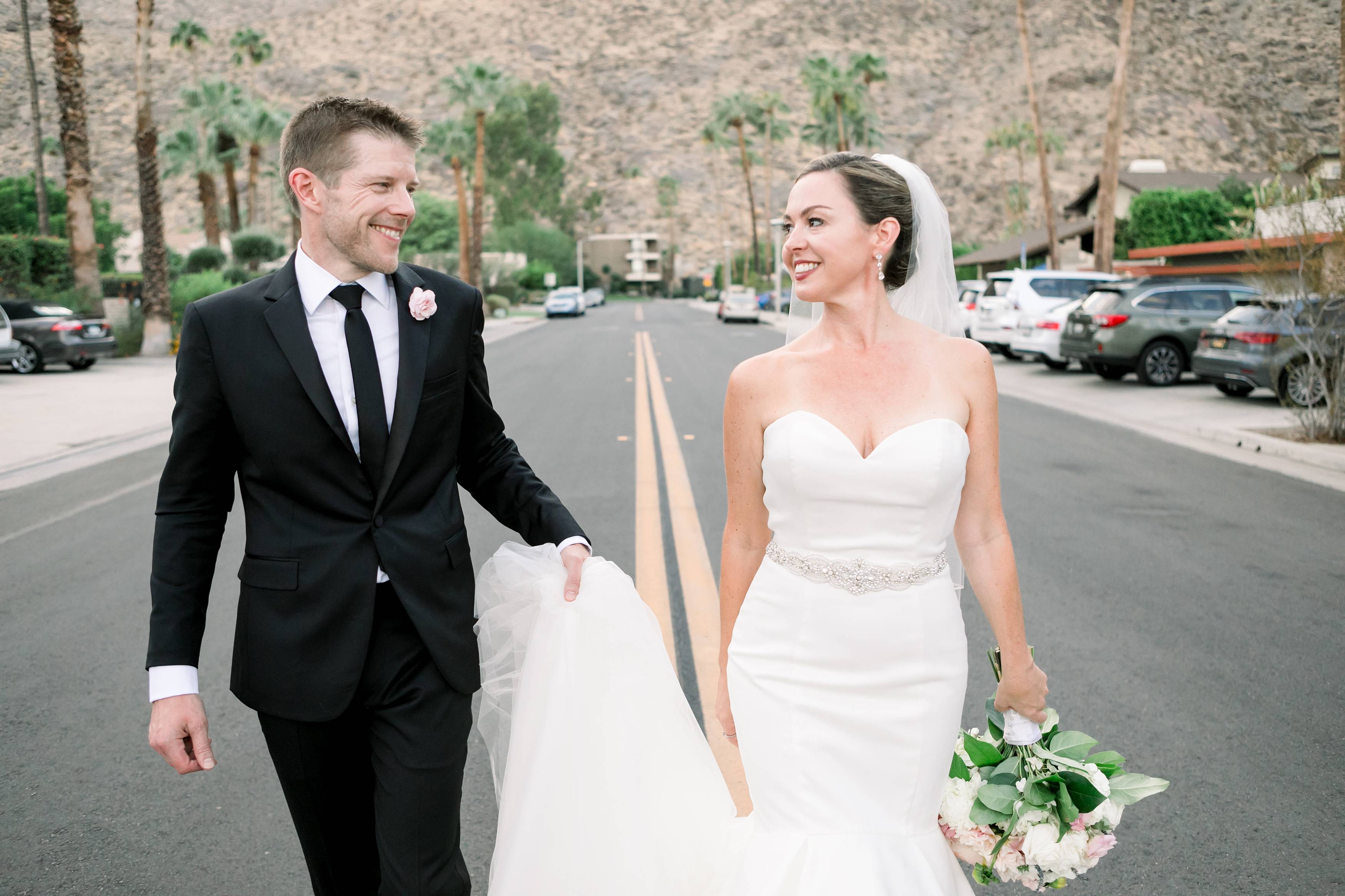 Bride and groom walk down the street in palm springs california at Amin Casa hotel shot by temecula wedding photographer carrie mcguire photography